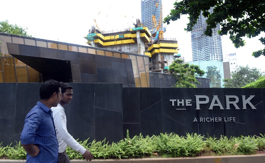 Men walk past Mumbai's "Trump Tower" in July 2015. It is still under construction.