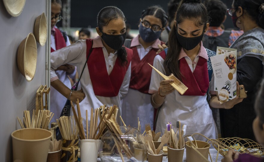 Schoolgirls look at items which are an alternate to plastic at an event to create awareness about eco-friendly products in New Delhi on Friday.