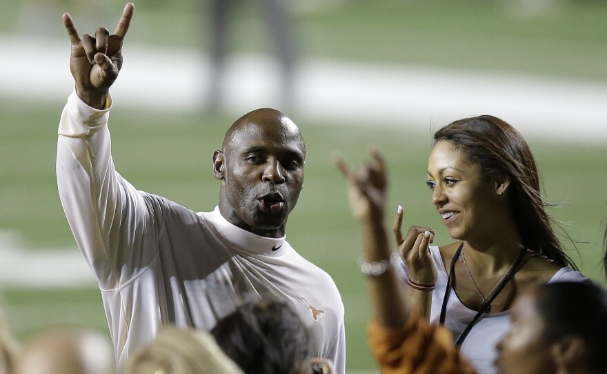 University of Texas football coach Charlie Strong holds up the "Hook' em Horns" sign as he sings the school song following an NCAA college football game against North Texas on Aug. 30. Texas won 38-7.