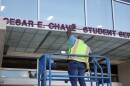 A worker removing César Chávez' name off the student services building at Southwestern College on March 19, 2026.