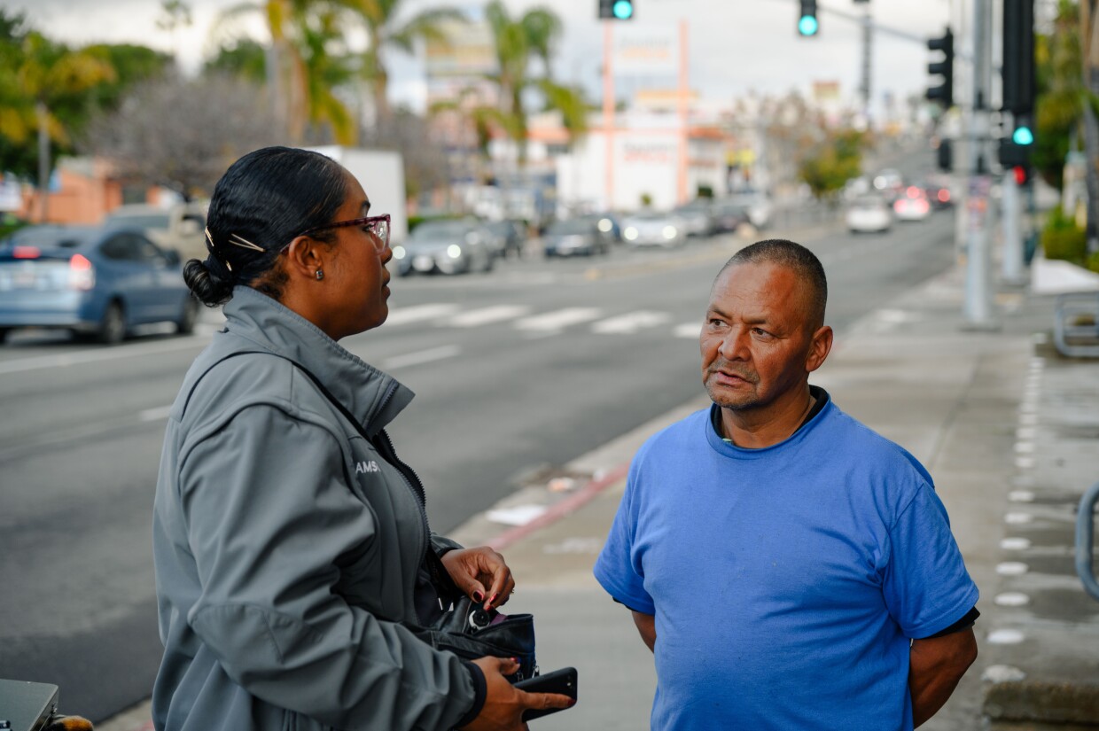 Qiana Williamson with National City’s HOME team talks with Alien Gonzalez, an unhoused client, on Highland Avenue in National City, California on March 7, 2024. National City is the second in San Diego County to move away from a police-led response to homelessness and toward trained caseworkers.