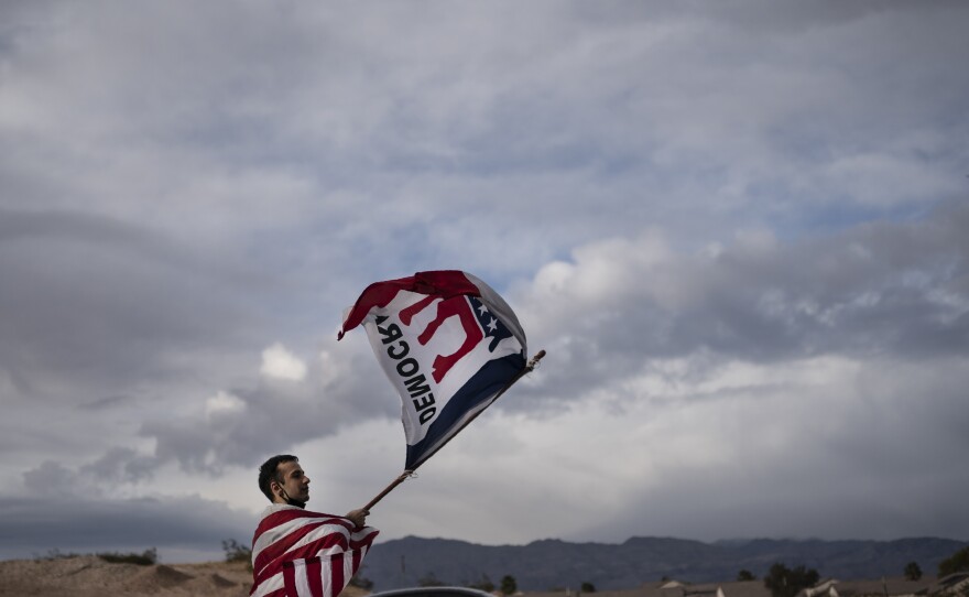 LAS VEGAS: A lone Biden supporter stands outside of the Clark County Elections Department in North Las Vegas, Saturday, Nov. 7, 2020.