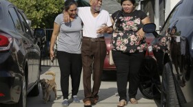 Aurelia Rodriguez, left, helps her father, Rodolfo Rodriguez, 92, center, with witness, Misbel Borjas, right, as he walks to talk to the media gathered outside his home in Los Angeles Wednesday, July 11, 2018.