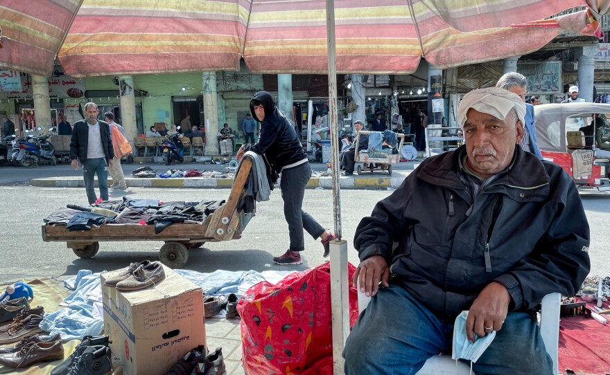 Razak Abdul-Zahra Mubarak, 70, sells used shoes on the street in al Maidan Square in Baghdad. "Each year it's getting hotter and hotter," he says — and even in winter he now needs the shade of an umbrella.
