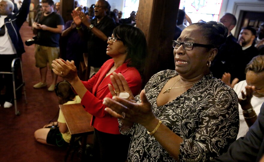 Rev. Jeannie Smalls, right, cries during a prayer vigil held at Morris Brown AME Church for the victims of Wednesday's shooting at Emanuel AME Church on Thursday, June 18, 2015 in Charleston, S.C.