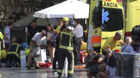 Injured people are treated in Barcelona, Spain, Thursday, Aug. 17, 2017 after a white van jumped the sidewalk in the historic Las Ramblas district, crashing into a summer crowd of residents and tourists and injuring several people, police said. 