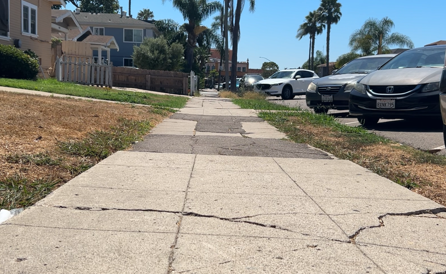 A bumpy, cracked, semi-repaired sidewalk in the North Park neighborhood of San Diego