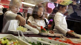 Children make salads from a salad bar.
