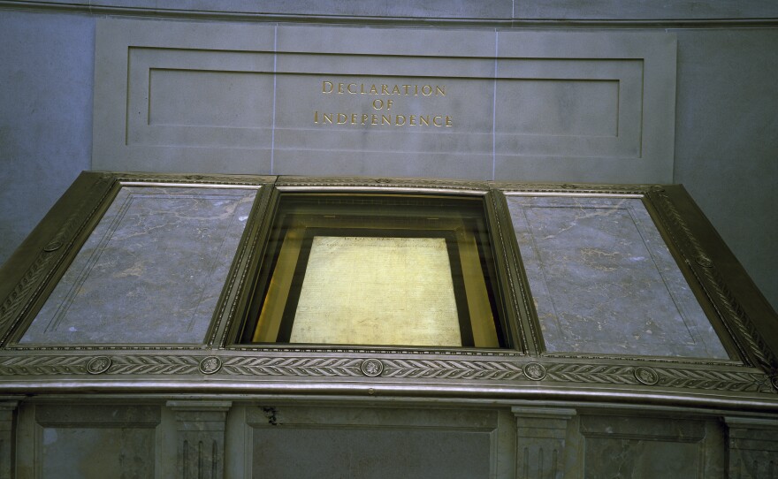 The Declaration of Independence, displayed in a dimly lit hall at the National Archives in Washington, D.C.