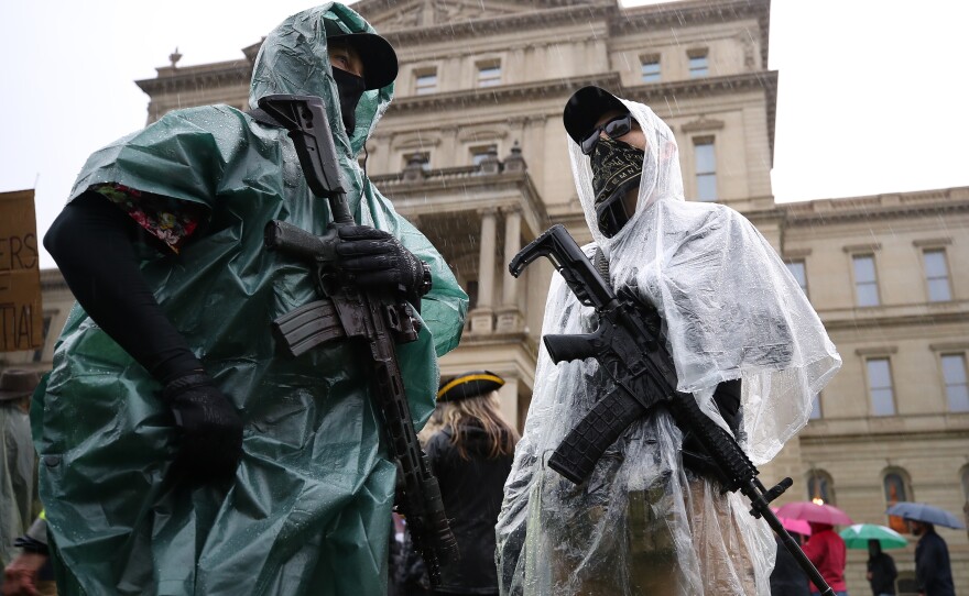 Protesters carrying weapons gather at the Michigan Capitol on Thursday in Lansing. Protesters are demonstrating against Democratic Gov. Gretchen Whitmer for the coronavirus stay-at-home order in effect through May 28.