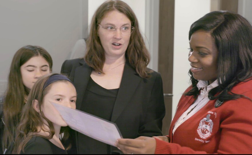 Two young girls and a woman talk to State Delegate Jennifer Carroll Foy push.