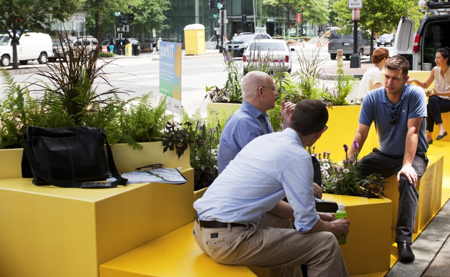 Will Handsfield (right), transportation director for the Georgetown Business Improvement District, talks with other parklet visitors in Washington, D.C. The Georgetown neighborhood hopes to have a parklet by September, and other areas may follow suit.