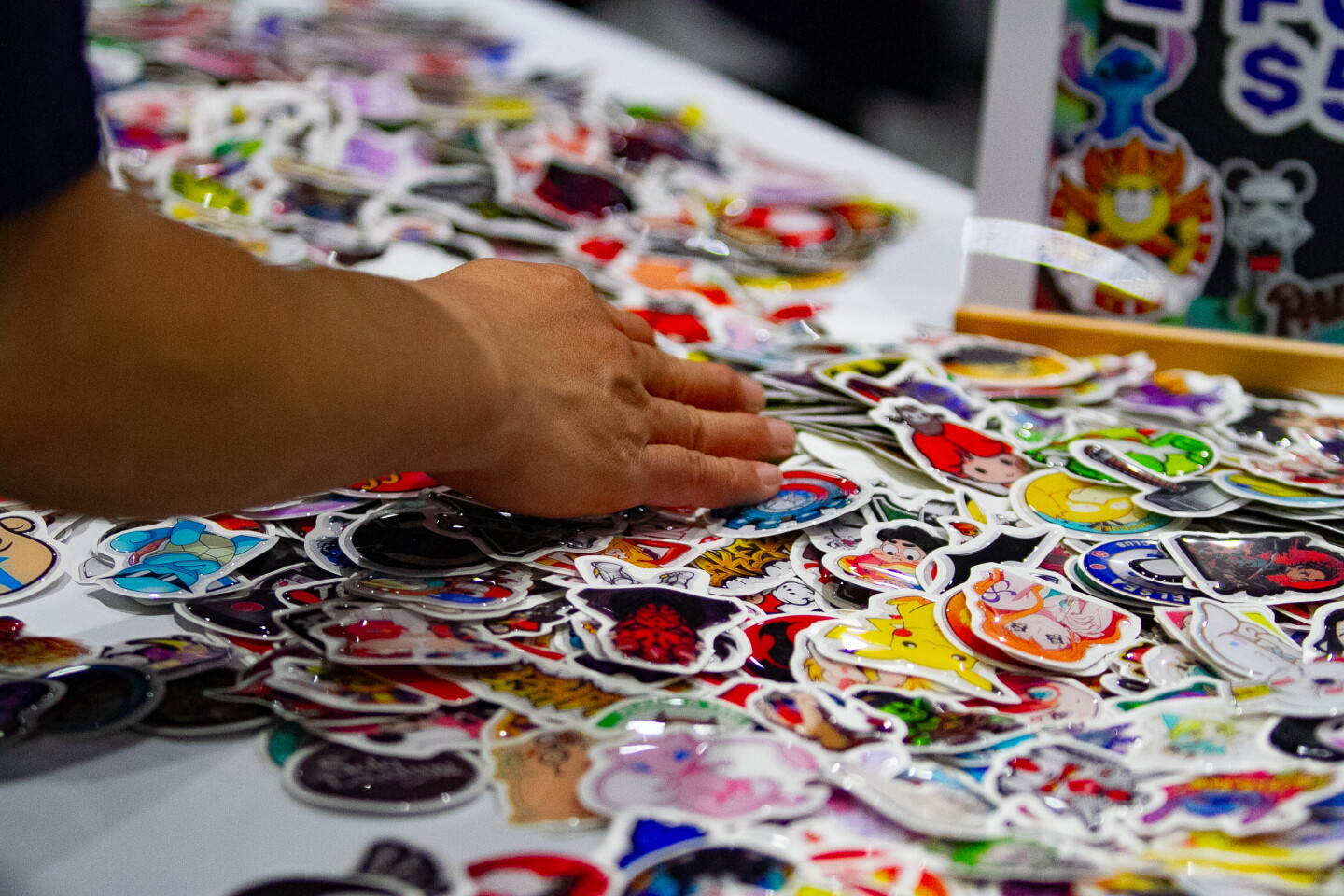 A man looks through stickers at a vendor booth during Comic-Con, April 23, 2026.