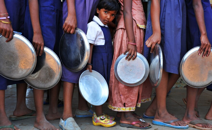 Indian schoolchildren wait in line for food at a government primary school in Hyderabad, India. Consistent access to nutritious food and clean water is key to help children thrive, researchers say.