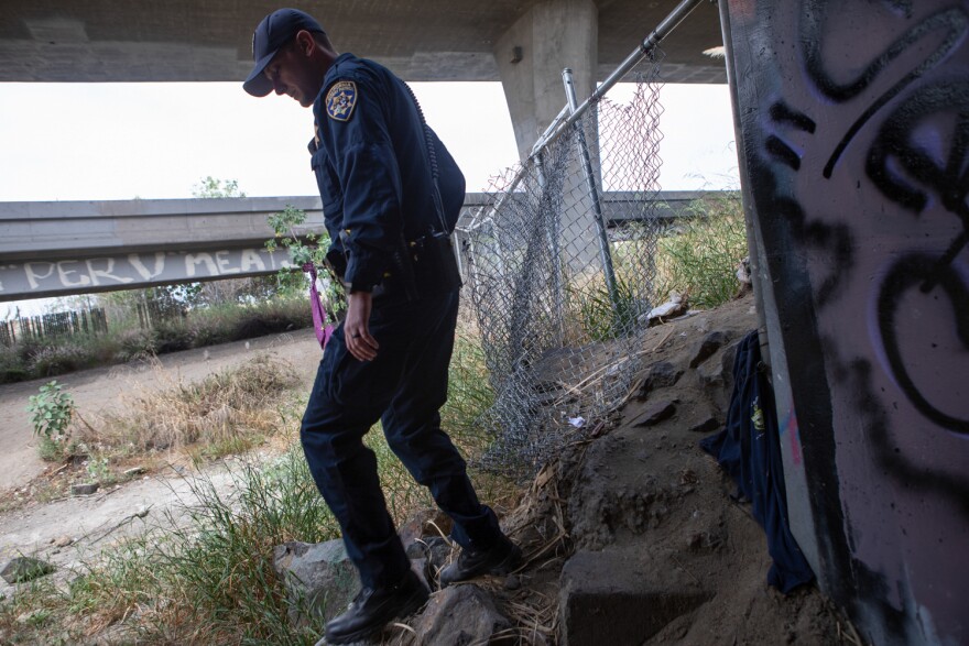 California Highway Patrol Officer Jesse Matias looks for individuals living under freeway ramps in Mission Valley, April 28, 2022. 