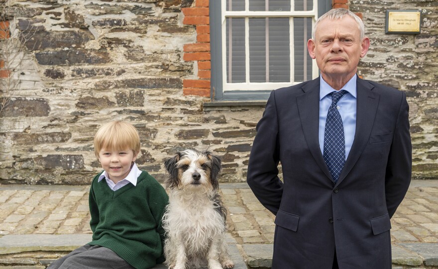 A year has passed since Martin (pictured with his child and dog) resigned his medical license, and his wife, Louisa, is now the one seeing patients in her new career change as a child counselor, while he looks after their two young children. DOC MARTIN: Season 10