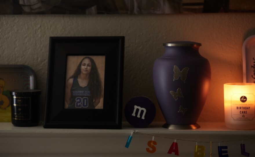 Family photos of Allyssa Lewis' family and her sisters ashes in her living room in Richardson, Texas, on April 4, 2022.