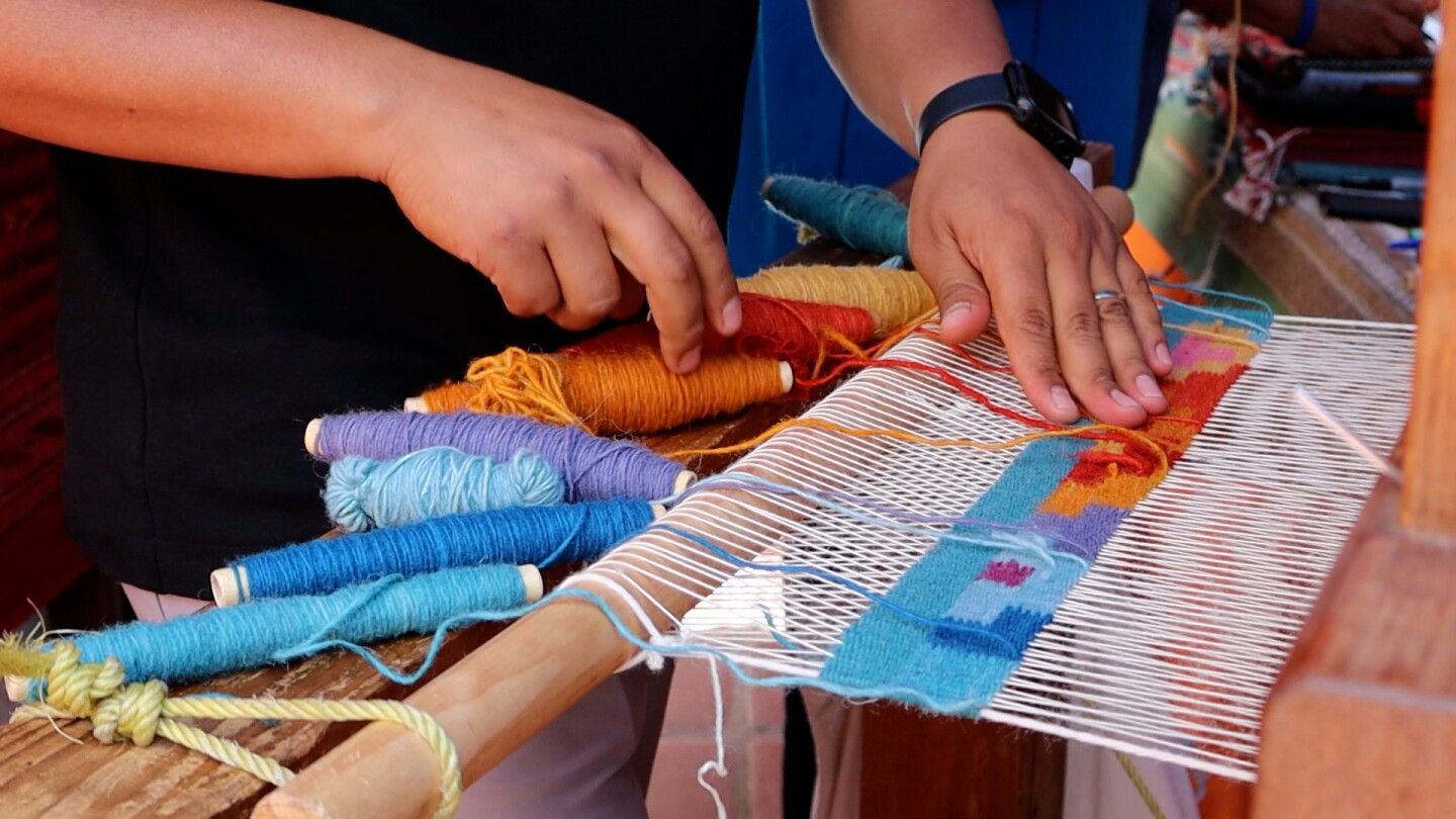 An artist creates a Zapotec woven rug on a pedal loom in Old Town San Diego's Bazaar Del Mundo on Friday, Aug. 1, 2025.