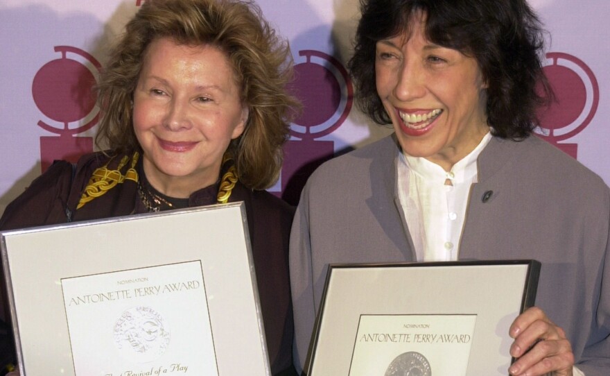 Jane Wagner (L) and Lily Tomlin hold up the Tony Award nominations they earned as producers of <em>The Search for Signs of Intelligent Life in the Universe</em> in 2001.
