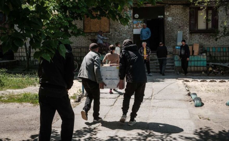 Residents receive food supplies May 7 as volunteers deliver daily from a warehouse of a humanitarian aid distribution center in Severodonetsk, eastern Ukraine