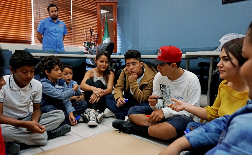 New arrivals to Mexico discuss challenges during a class at the Tijuana Education Department.