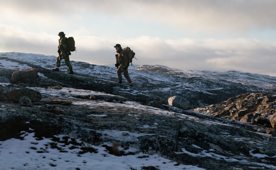 Two privates walk on the mountain just outside the border post.