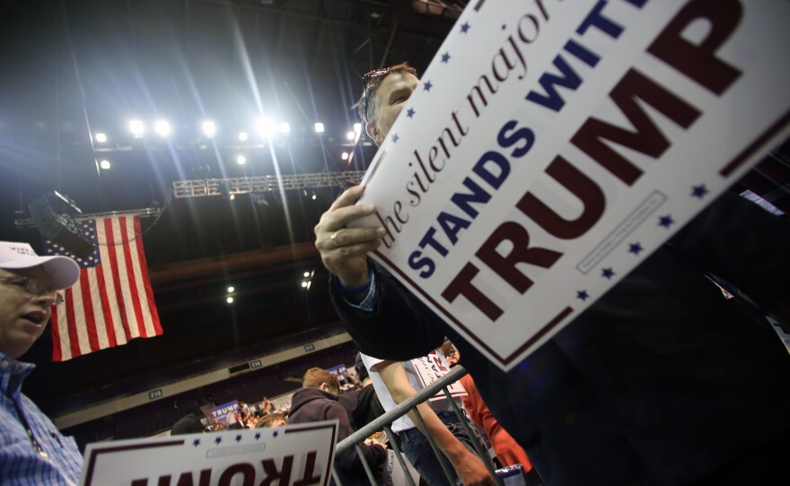 Supporters hand out placards during Republican presidential candidate Donald Trump's campaign rally in Pensacola, Fla.
