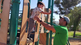 Vince LaPietra helps his son Teddy play on a playground in Balboa Park, Aug. 14, 2022.