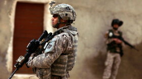 An Iraqi army soldier and a U.S. Army soldier stand guard during a joint patrol in Mosul in March 2009.