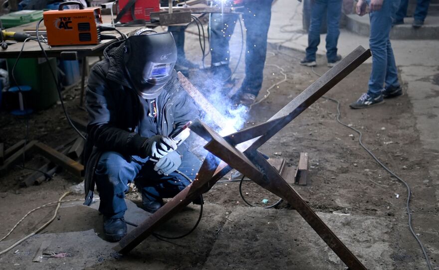 Volunteers connect I-beams to make anti-tank obstacles known as Czech hedgehogs, in a workshop in Lviv, western Ukraine, on March 3.