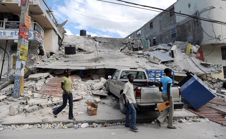 Pedestrians walk past the rubble of a building destroyed by a massive earthquake in Port-au-Prince, Haiti, on Jan. 13, 2010. Tens of thousands perished in the quake.