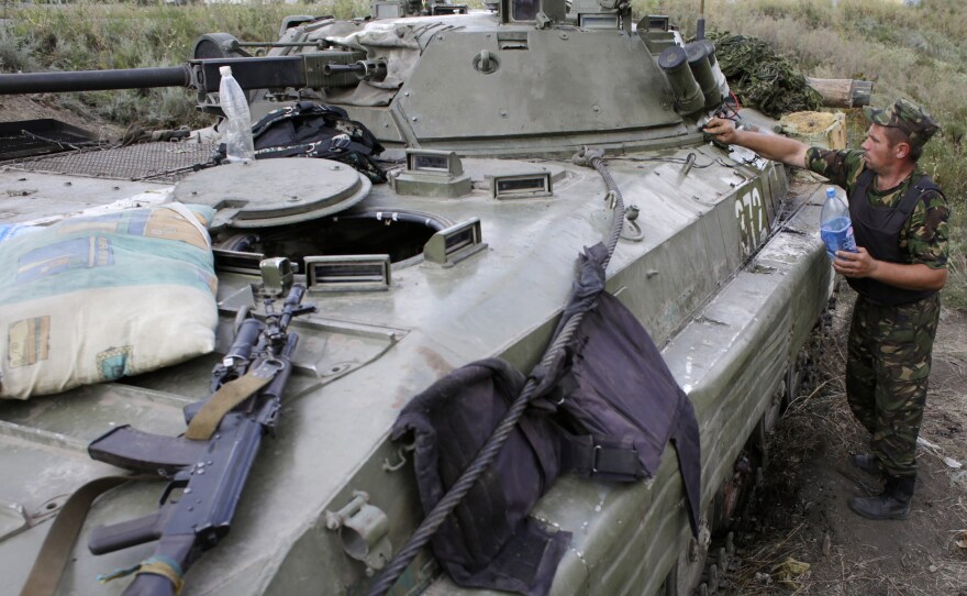 A Ukrainian soldier cleans his armored personnel carrier near Donetsk in eastern Ukraine Monday. Russia says a large convoy that's heading to the area from Moscow is carrying humanitarian aid.