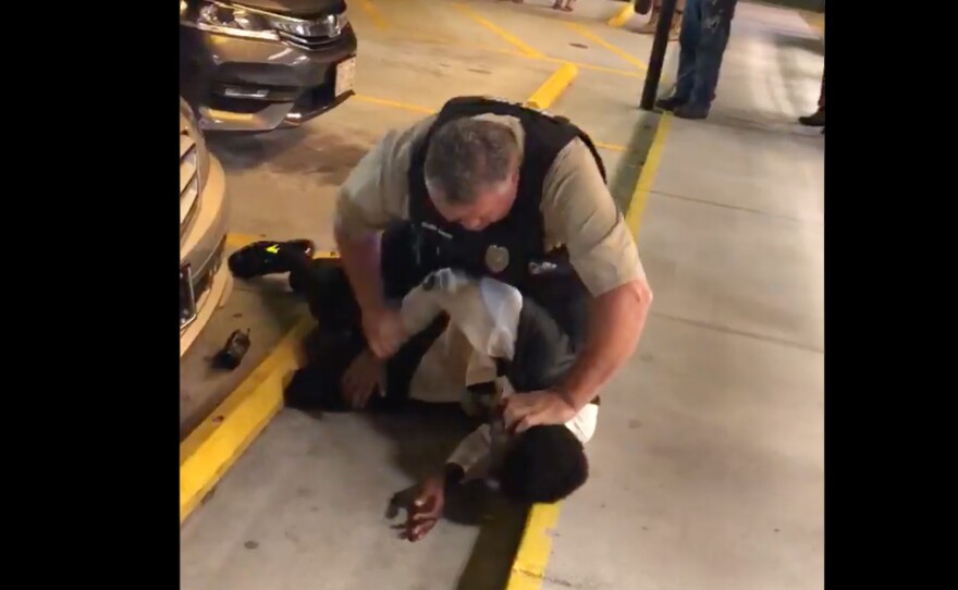 The video shows a white police officer choking a young tuxedo-clad man who is African-American, pushing him against a storefront and then slamming him to the ground outside a North Carolina Waffle House.