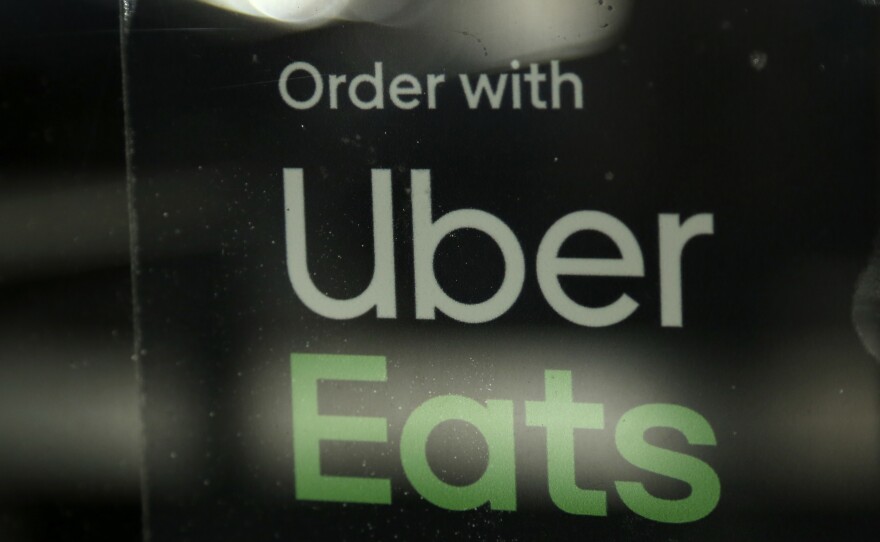 In this Nov. 6, 2019, file photo, a restaurant advertises Uber Eats in the Coconut Grove neighborhood in Miami.