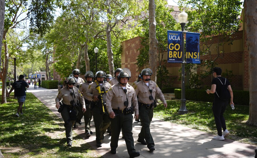 Police walk on the UCLA campus after nighttime clashes between Pro-Israel and Pro-Palestinian groups, Wednesday, May 1, 2024, in Los Angeles.