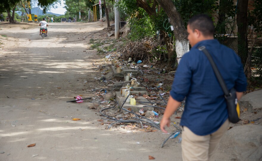 Community leader Carlos Ramos stands by one of the major water connection points in La Paz, where residents hook up their motor pumps to push water from the main pipe through their hoses into their home cisterns<em> </em>hundreds of feet away.
