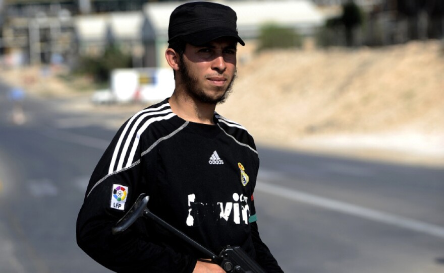 A Libyan rebel stands guard at the entrance to the Zawiya oil refinery, about 30 miles west of Tripoli, on Aug. 19. Rebels have taken complete control of the key oil refinery. Before the conflict, Libya supplied 2 percent of the world's oil, but restarting oil field operations won't be a simple task.