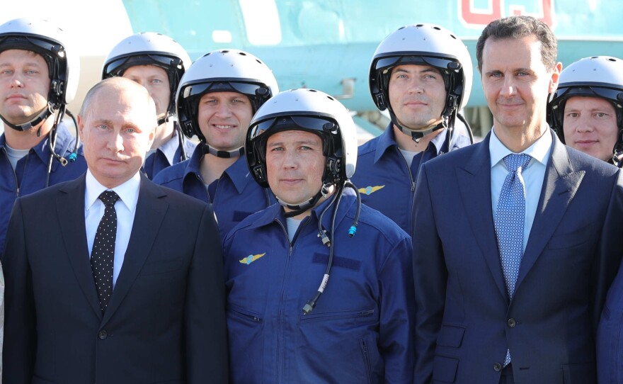 Russian President Vladimir Putin, left, and Syrian President Bashar Assad, right, pose for a photo with Russian military pilots at the Hemeimeem air base in Syria last December.