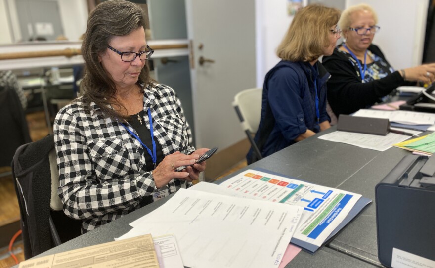 Election worker Nancy Riley uses her phone during a break from training, Feb. 25, 2020.