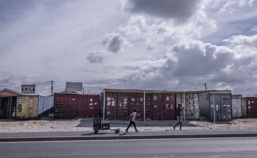 Boys walk past shuttered businesses in the township of Khayelitsha, Cape Town, South Africa, during the country's coronavirus lockdown.