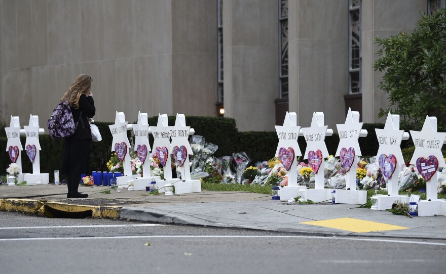 A woman stands at a memorial outside the Tree of Life synagogue after a shooting there left 11 people dead in the Squirrel Hill neighborhood of Pittsburgh on Saturday.