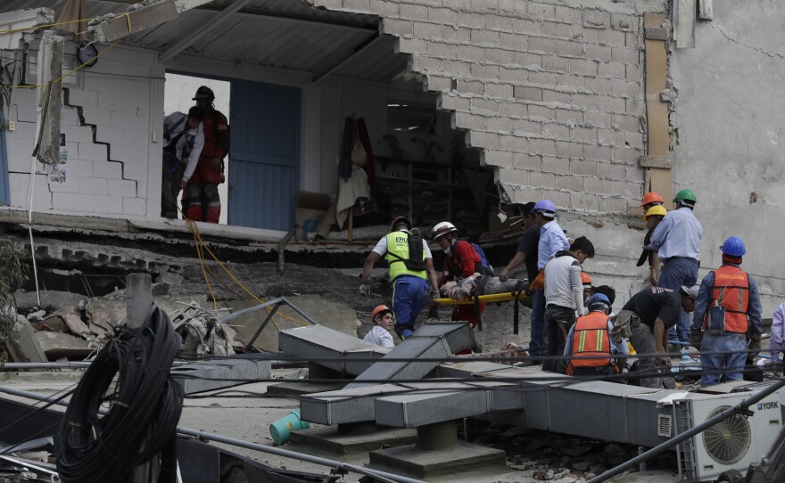 An injured woman is carried out of a building that collapsed during an earthquake in Mexico City, Tuesday, Sept. 19, 2017.