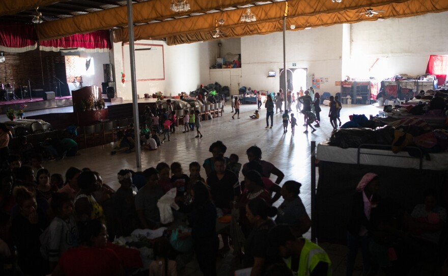 Dozens of people wait in line for a clothing donation distribution at the Templo Embajadores de Jesús shelter in Tijuana, June 1, 2022. 