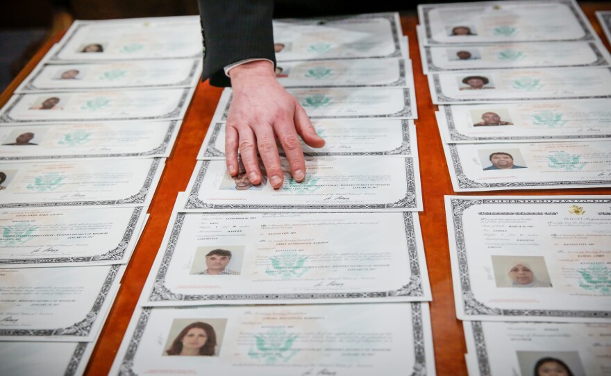 Before the official ceremony, immigrants double-check their certificates of citizenship for any incorrect information.