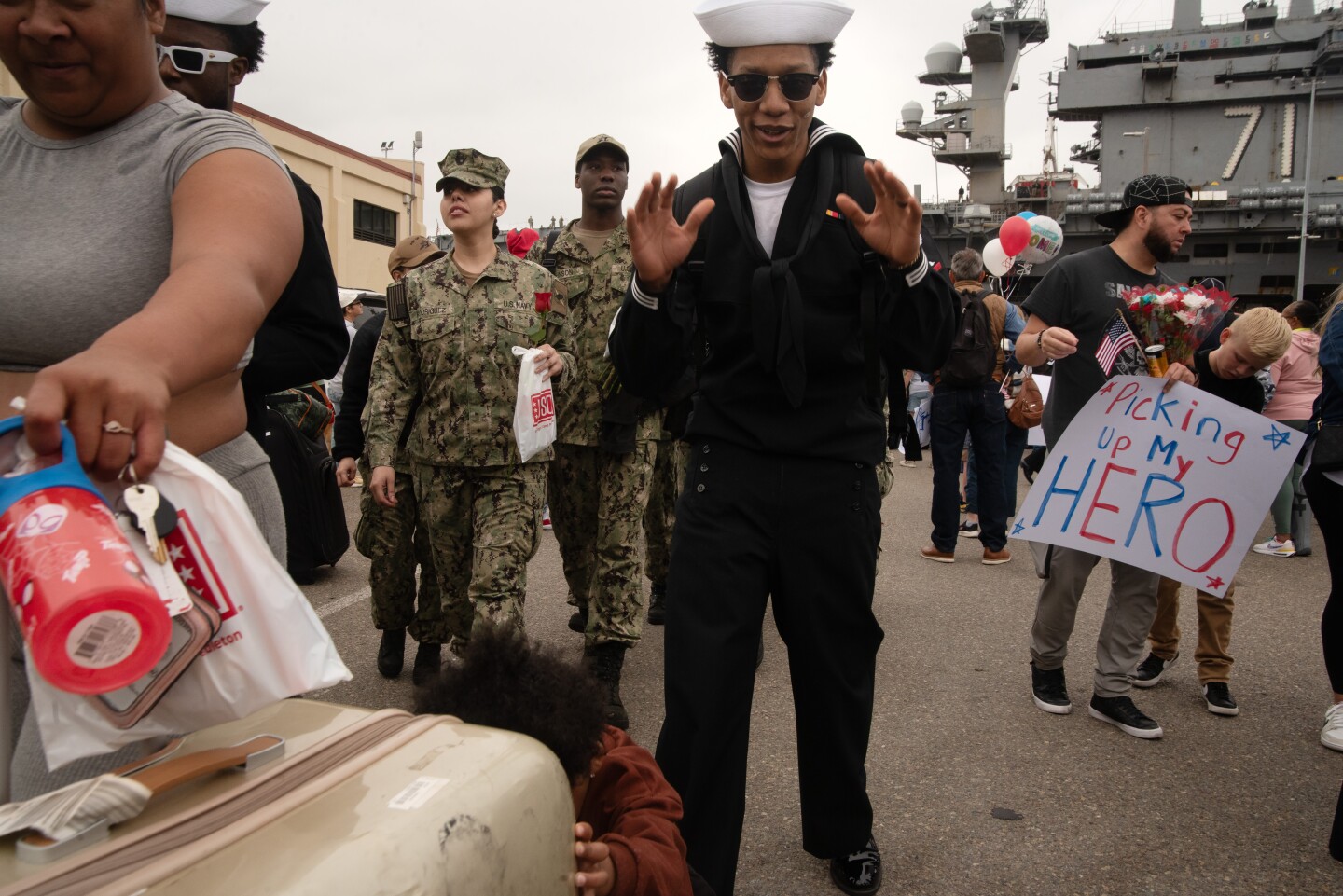 A sailor's child helps his mother push his belongings after departing from the the aircraft carrier Theodore Roosevelt on Oct. 15, 2024 at the Naval Air Station North Island on Coronado Island.