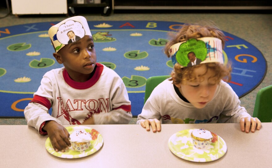 Jonah Hack (left) and Kieran Dockett-Gilbert wait for Barnhardt's permission to dig into their cupcakes. The treats were part of their Rev. Martin Luther King Jr. birthday celebration on Friday, which also included songs and stories.