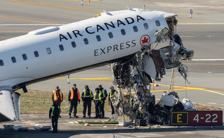 Aircraft maintenance workers inspect the wreckage of an Air Canada Express jet, Tuesday, March 24, 2026, just off the runway where it collided with a Port Authority fire truck Sunday night at LaGuardia Airport in New York.