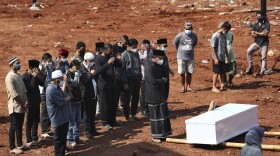 An Islamic cleric leads relatives in prayer during the burial of a man at the special section of Jombang Public Cemetery reserved for those who died of COVID-19, in Tangerang, on the outskirts of Jakarta, Indonesia, Wednesday, Aug. 4, 2021. 
