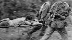 Soldiers transport a wounded man, Okinawa, 1945.