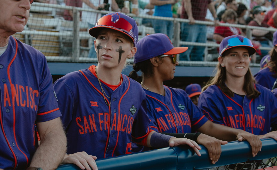 San Francisco Firebells coach Matt Williams (from left), second baseman Amanda Gianelloni, catcher Samantha Gutierrez and left fielder Skylar Kaplan in the dugout prior to their game on Sunday, Aug. 2.